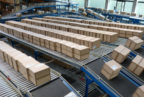 Zdjęcie prezentujące przenośniki rolkowe transportujące paczki